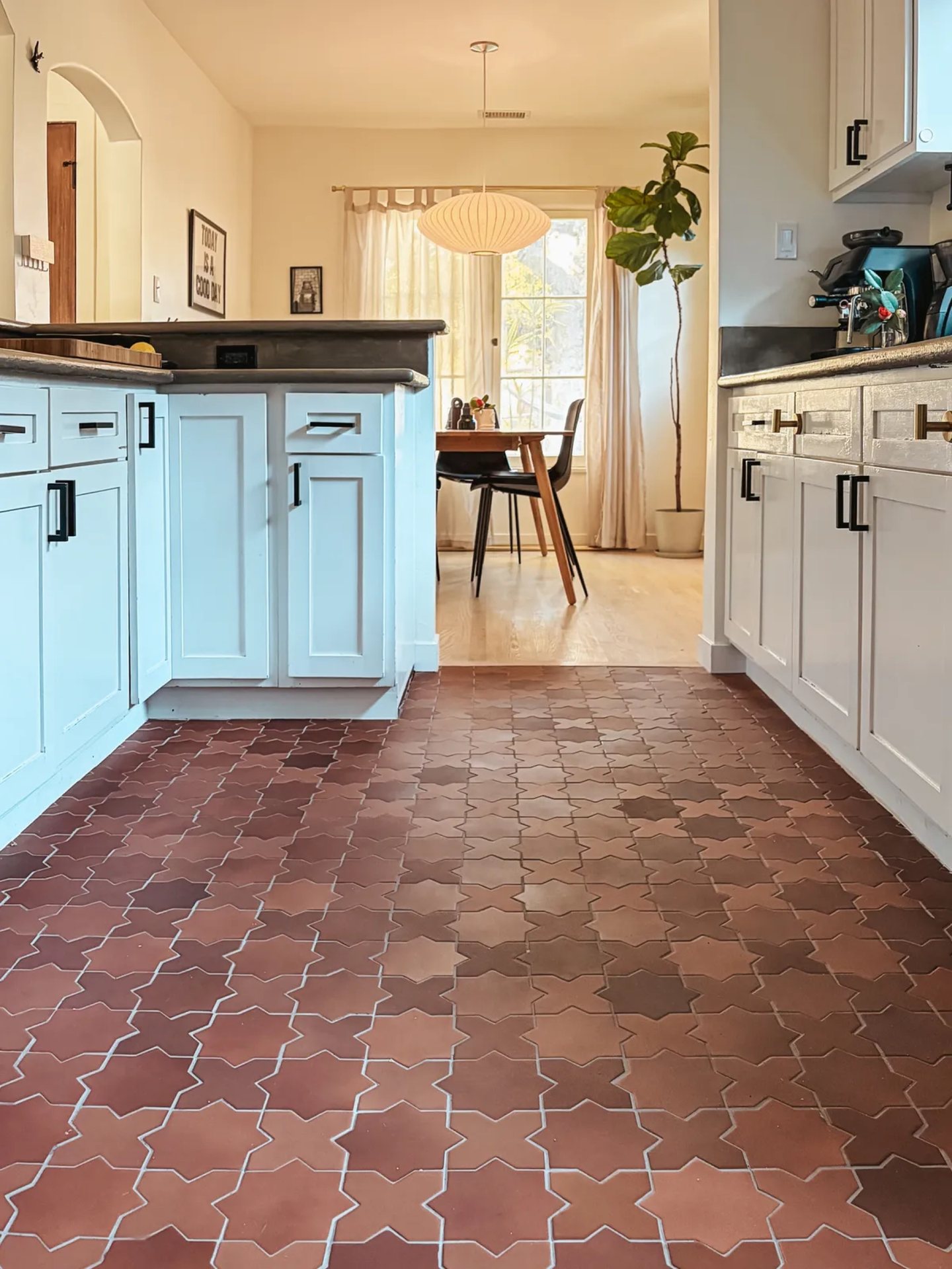 Patterned terracotta tile floor in a warm wood kitchen